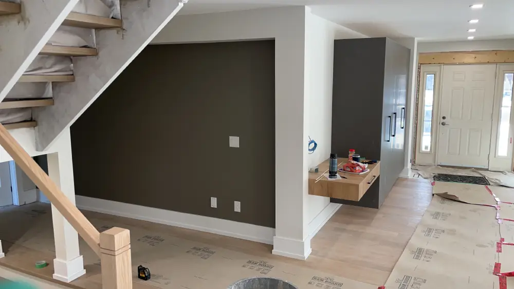 Interior Accent Wall Painting in Richmond Hill – Dark Feature Wall Home Renovation Dark charcoal accent wall painting with white trim and open staircase in a home renovation project in Richmond Hill Ontario