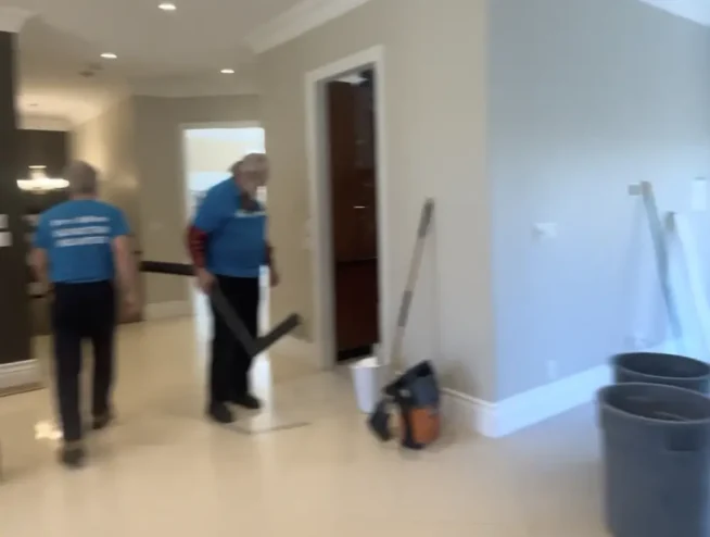 Two Razco Renovation team members in blue uniforms working inside a residential home during an interior renovation