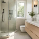 Renovated small bathroom in Toronto with a walk-in glass shower and floating wood vanity