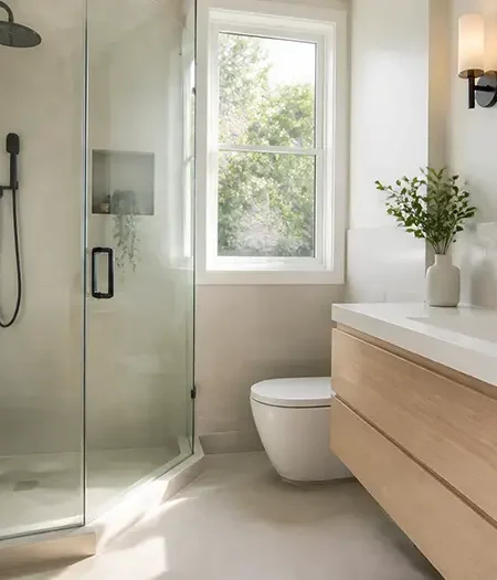 Renovated small bathroom in Toronto with a walk-in glass shower and floating wood vanity